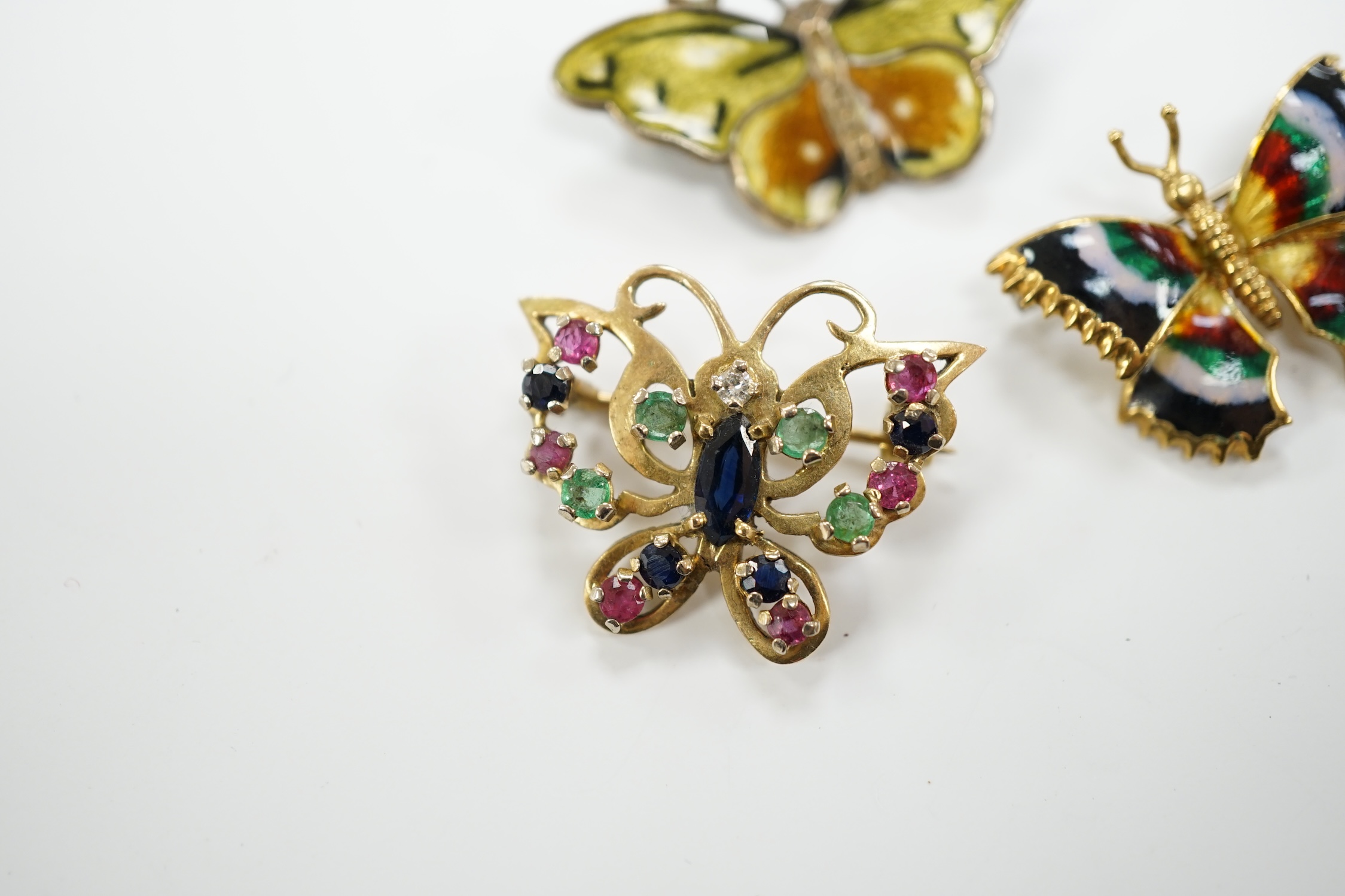 Three assorted butterfly brooches, sterling and enamel, 18k and enamel and 9ct gold and gem set, width 25mm.